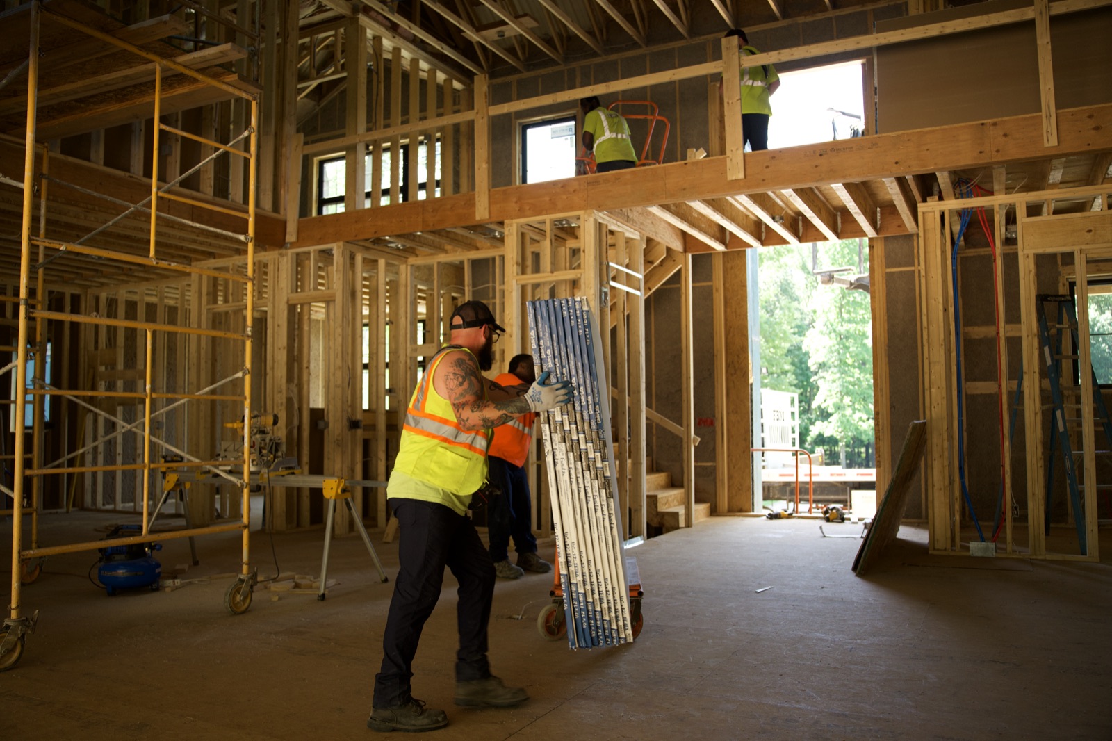 Hanging drywall inside a newly framed home