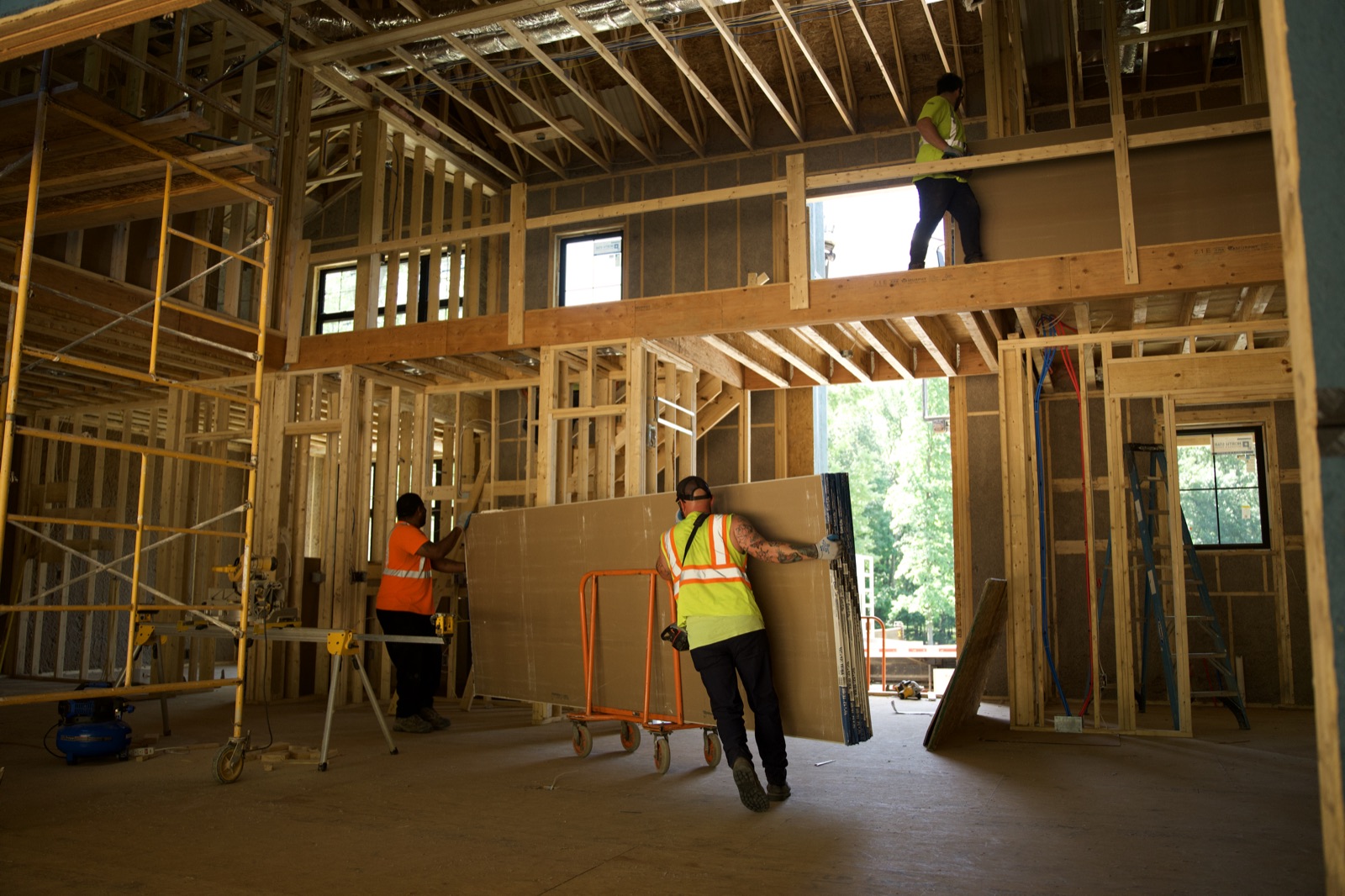 Crew staging drywall inside a framed great room